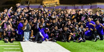 Diamond Bar Brahmas football players celebrate on the field holding the Branding Iron trophy after their 30–7 win over Walnut in the Hacienda League opener.