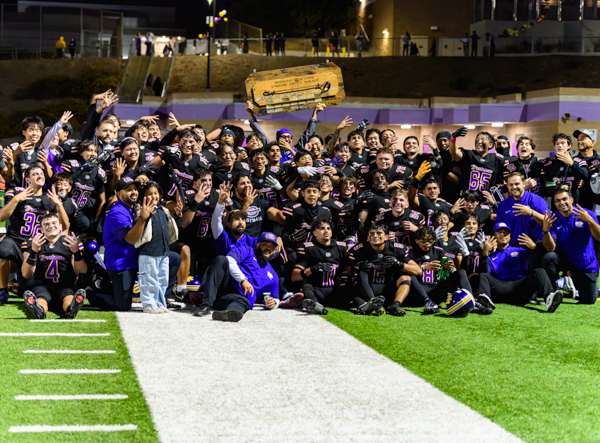 Diamond Bar Brahmas football players celebrate on the field holding the Branding Iron trophy after their 30–7 win over Walnut in the Hacienda League opener.